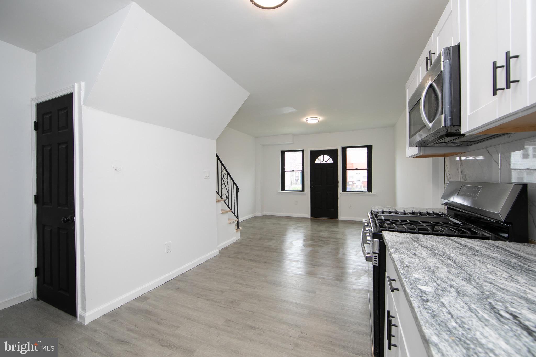 1261 South Merrimac Road Camden, NJ 08104 - Photo 7 of 27 a kitchen with granite countertop a stove and a wooden floors