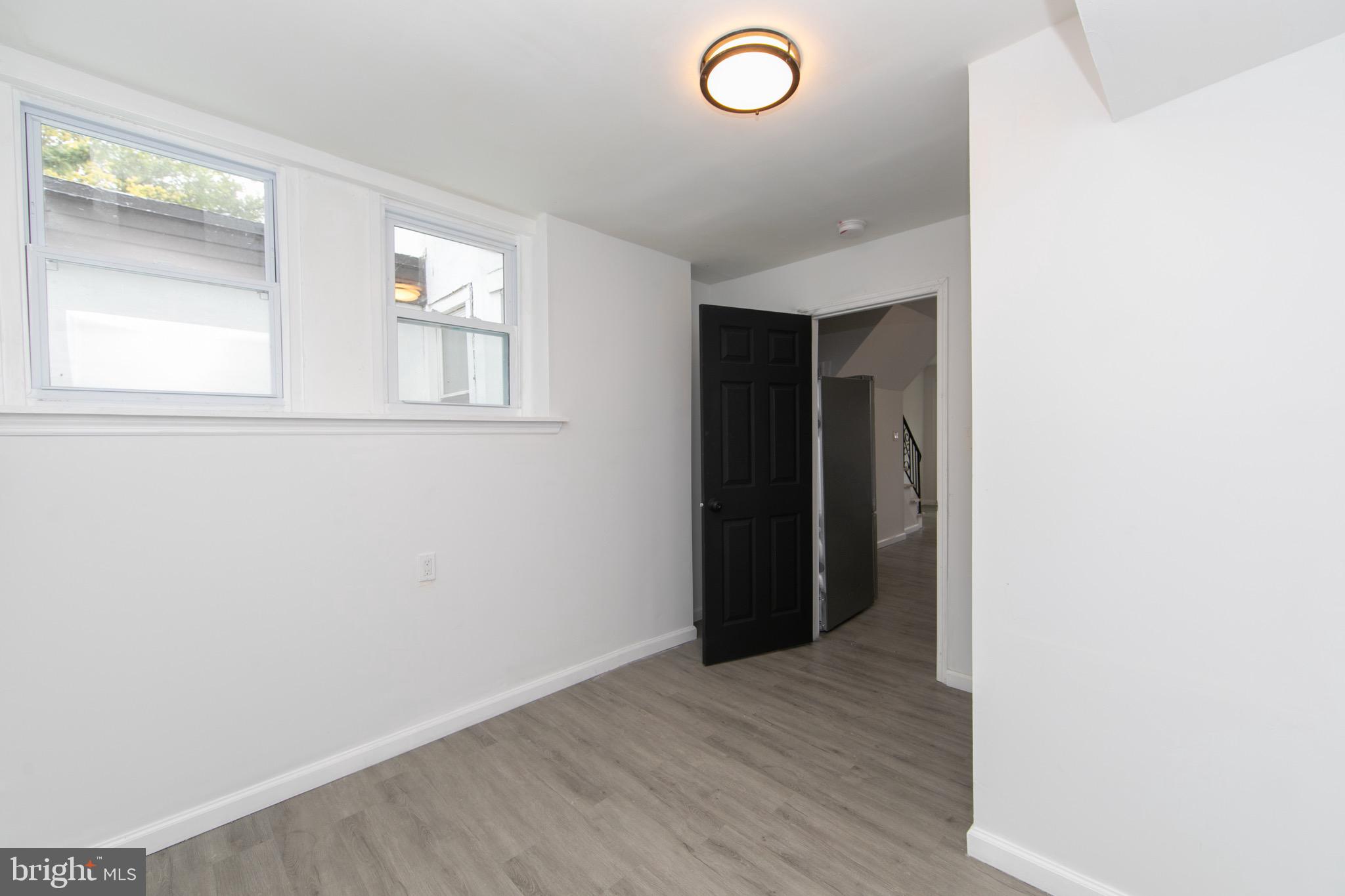 1261 South Merrimac Road Camden, NJ 08104 - Photo 10 of 27 an empty room with wooden floor and windows