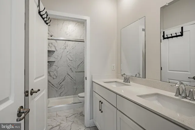 a bathroom with a granite countertop sink mirror and shower