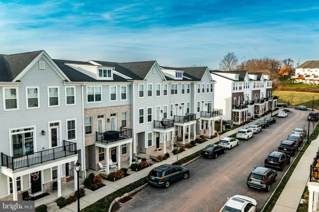 a view of a city that has tall buildings and cars parked