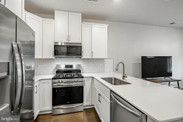 a kitchen with appliances a sink and cabinets