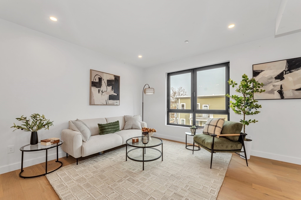 3992 Washington Street, Unit 302 Boston, MA 02131 - Photo 10 of 29 a living room with furniture and flowers