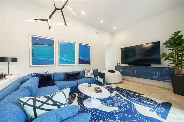 a dining room with wooden floor a chandelier a wooden table and chairs