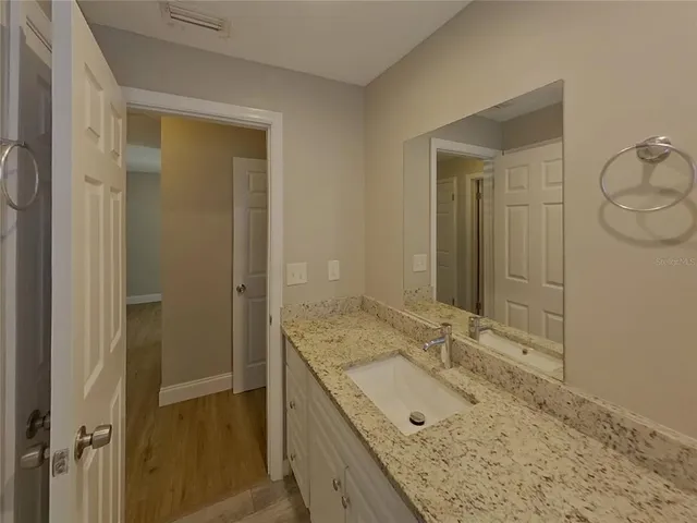 a bathroom with a granite countertop sink and a mirror