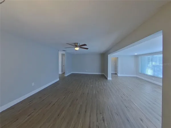 a view of empty room with wooden floor