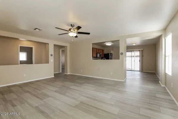 a view of an empty room with window and wooden floor
