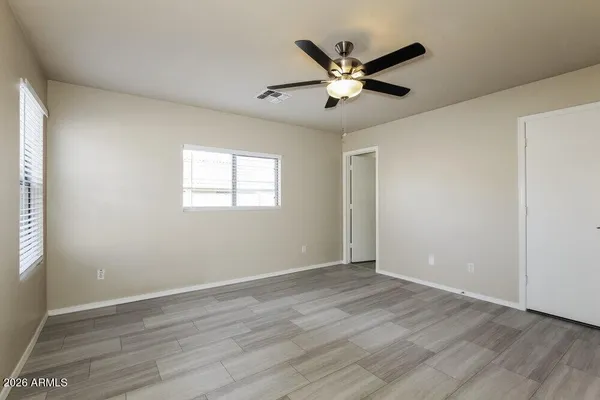 a view of a big room with wooden floor closet and windows
