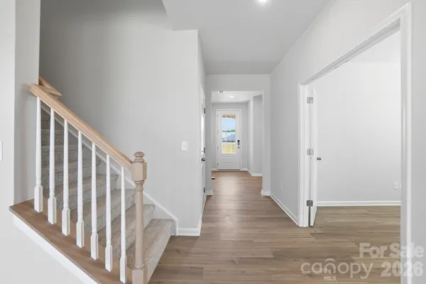 a view of a hallway with wooden floor and staircase