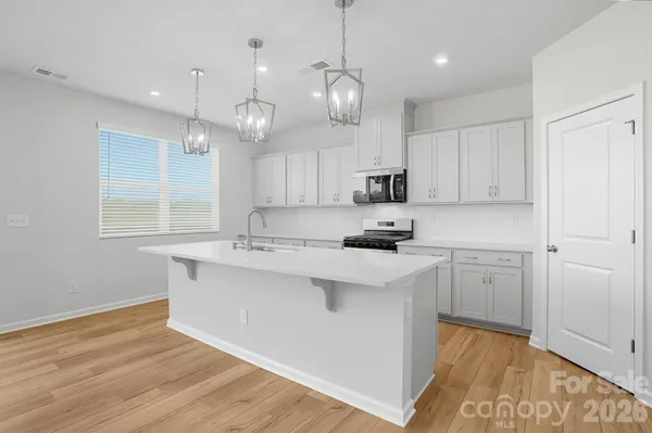 a kitchen with kitchen island white cabinets and white appliances