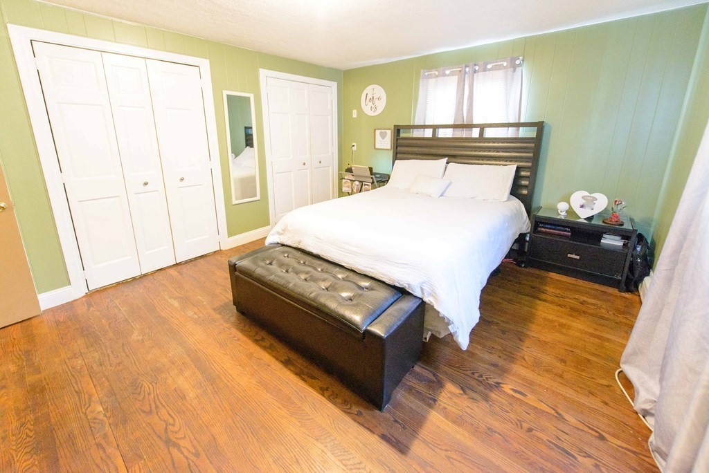 99 Merrill Road Springfield, MA 01119 - Photo 20 of 30 a bedroom with a bed and wooden floor