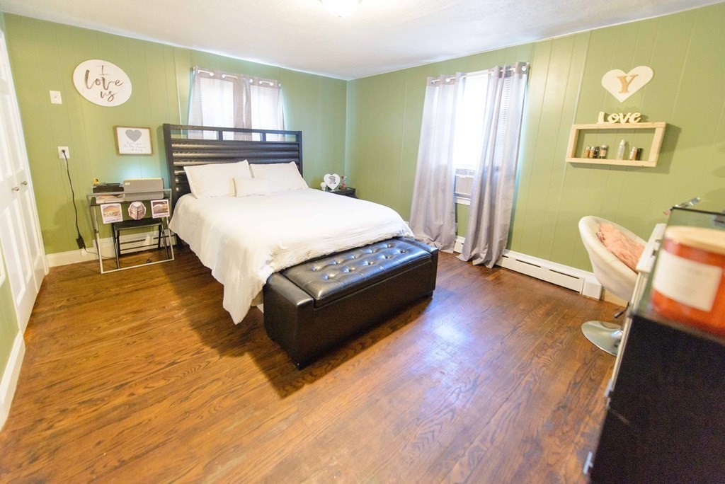 99 Merrill Road Springfield, MA 01119 - Photo 21 of 30 a bedroom with a bed and wooden floor