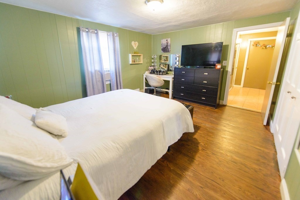 99 Merrill Road Springfield, MA 01119 - Photo 22 of 30 a bedroom with a bed and a flat screen tv