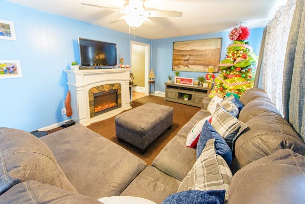 99 Merrill Road Springfield, MA 01119 - Photo 7 of 30 a living room with furniture a flat screen tv and a fireplace