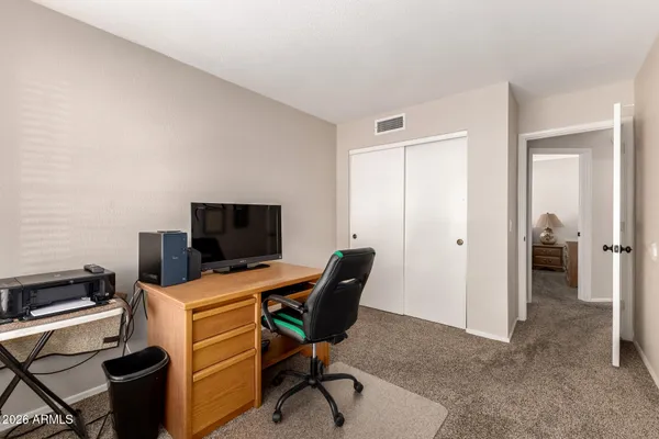 a view of a workspace with furniture and a window