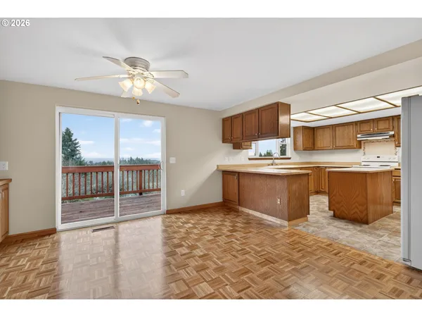 a kitchen with stainless steel appliances a sink a stove a refrigerator cabinets and a window