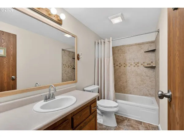 a bathroom with a granite countertop sink toilet a shower and a mirror