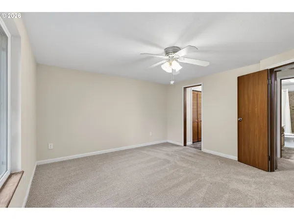 a view of an empty room with a ceiling fan