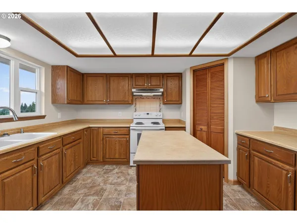 a kitchen with a sink a stove cabinets and wooden floor