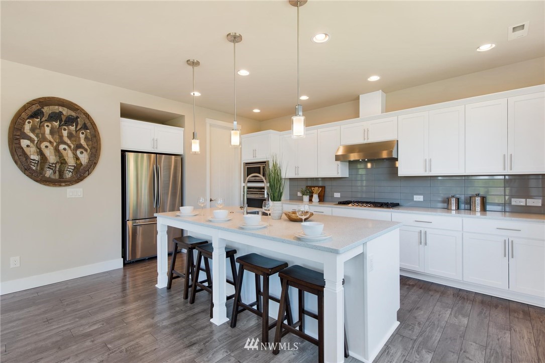 27418 Northeast 152nd Court Duvall, WA 98019 - Photo 4 of 40 a kitchen with stainless steel appliances a table chairs refrigerator and cabinets