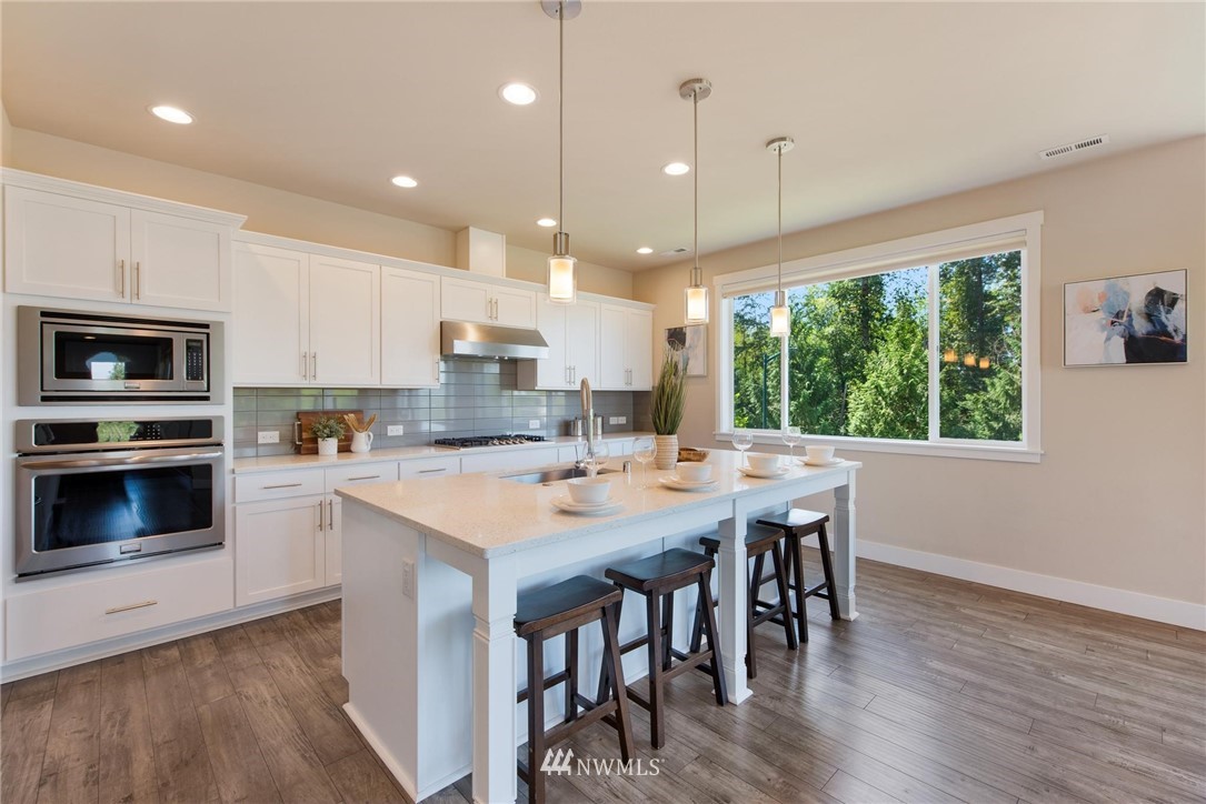 27418 Northeast 152nd Court Duvall, WA 98019 - Photo 5 of 40 a kitchen with a table chairs microwave and cabinets