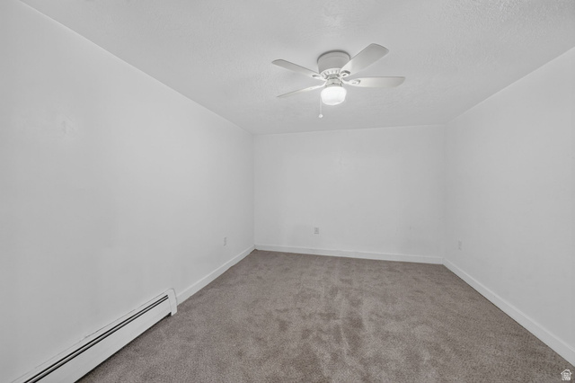 220 East Greenwood Avenue Midvale, UT 84047 - Photo 35 of 46 Neutral tone interior featuring a ceiling fan with light fixture, baseboard heating, clean white walls, and gray carpet flooring