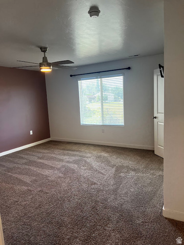 562 Hal Street, Unit 152 Tooele, UT 84074 - Photo 23 of 44 Spacious room featuring broadloom carpet, a ceiling fan with integrated lighting, and a window with horizontal blinds