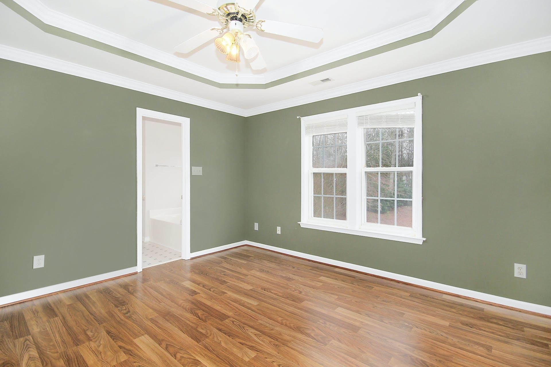 143 Susan Drive Garner, NC 27529 - Photo 15 of 27 an empty room with wooden floor chandelier fan and windows