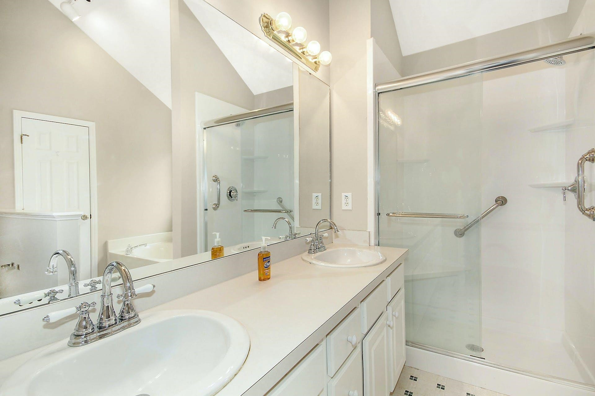 143 Susan Drive Garner, NC 27529 - Photo 16 of 27 a bathroom with a double vanity sink mirror and shower