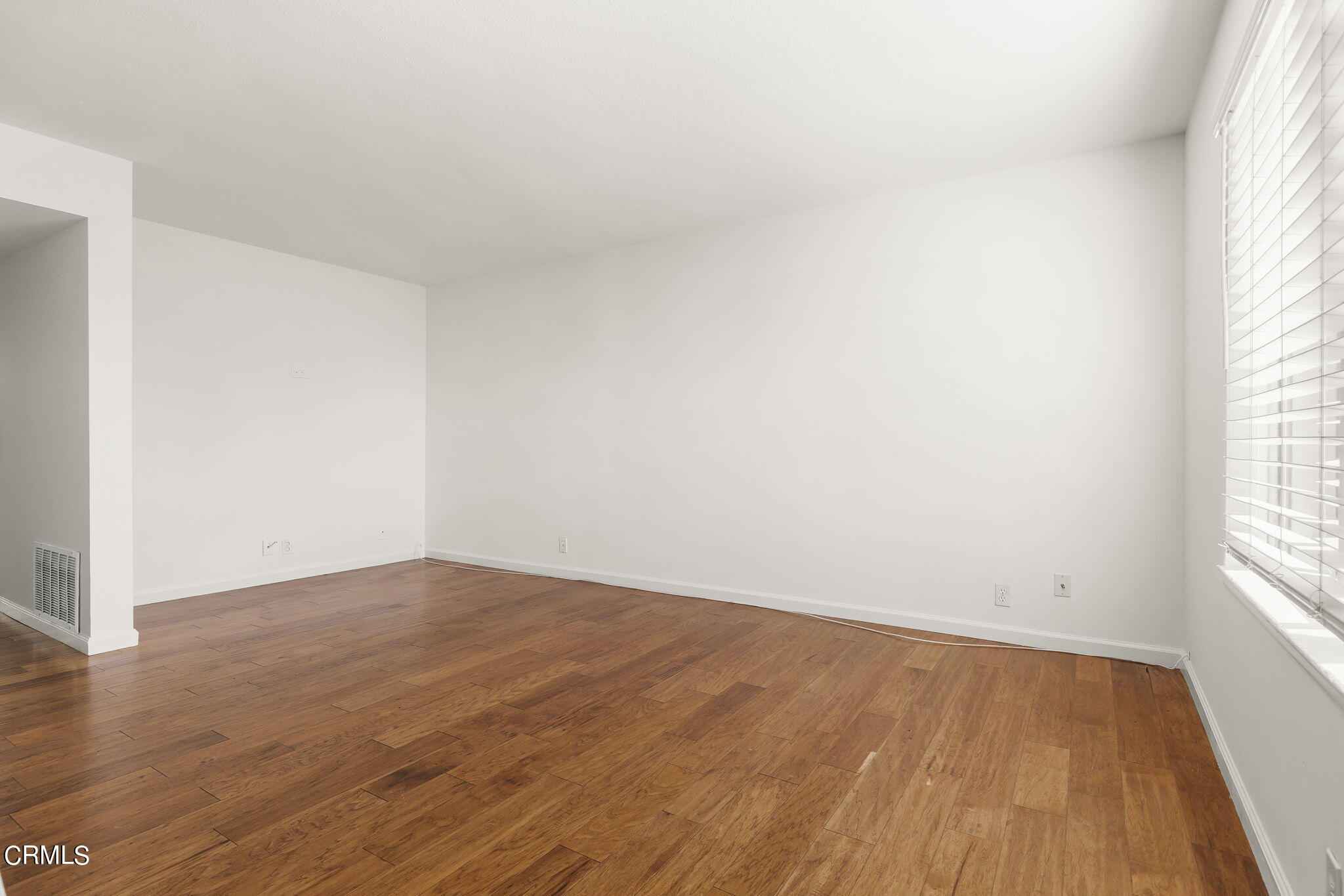 1440 Friedrich Lane, Unit C Oxnard, CA 93033 - Photo 5 of 30 an empty room with wooden floor and windows
