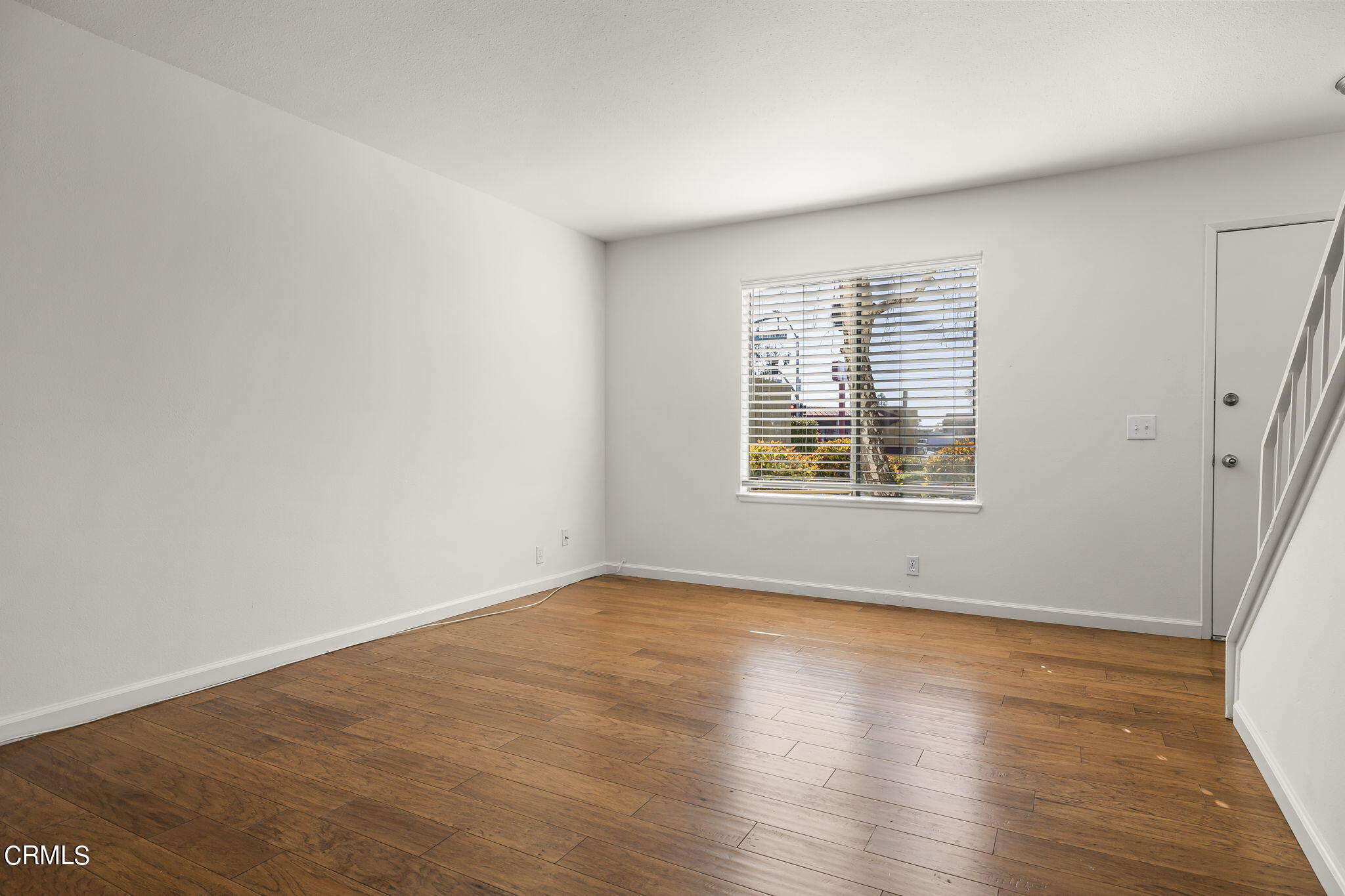 1440 Friedrich Lane, Unit C Oxnard, CA 93033 - Photo 7 of 30 a view of an empty room with wooden floor and a window