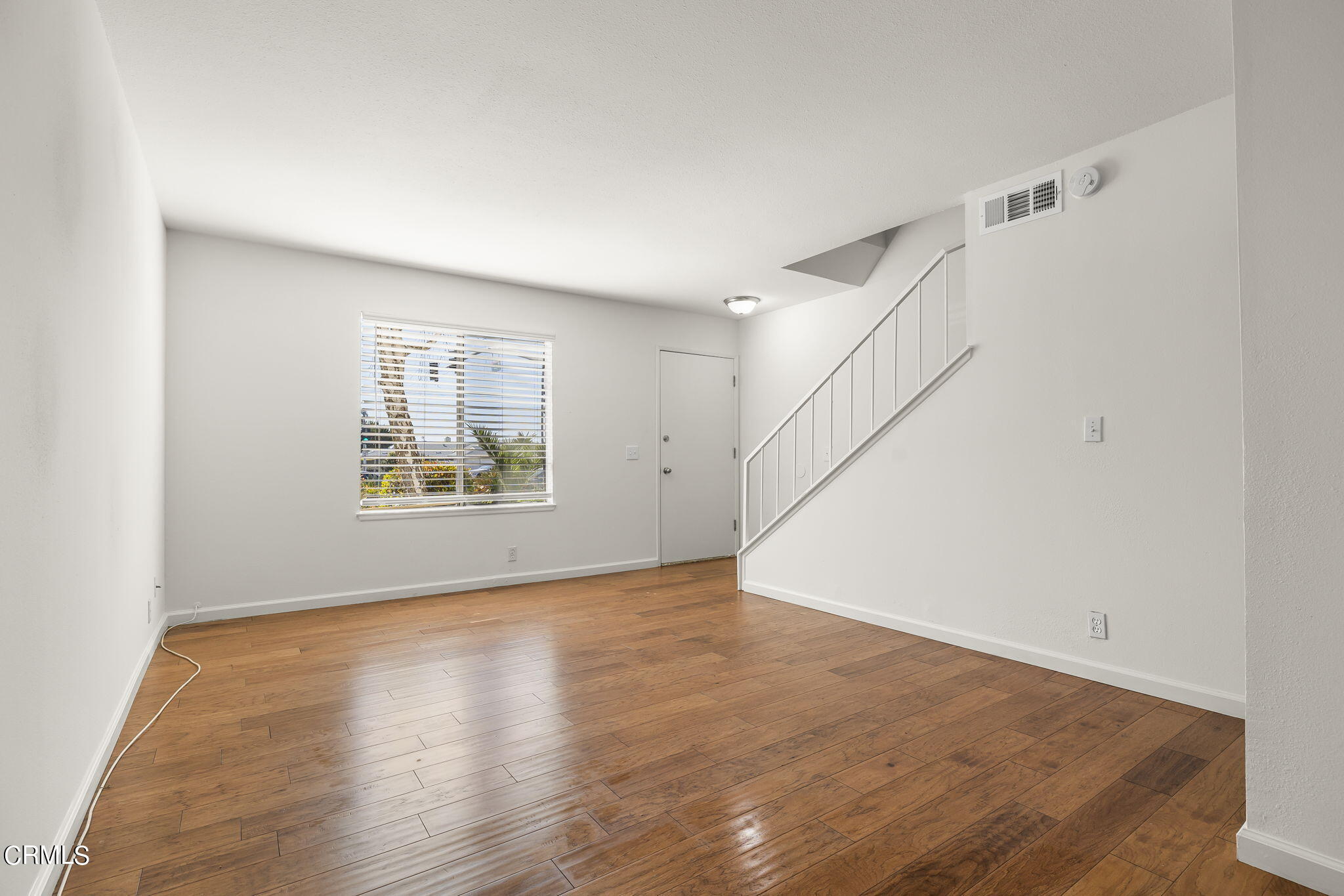 1440 Friedrich Lane, Unit C Oxnard, CA 93033 - Photo 8 of 30 a view of an empty room with wooden floor and a window