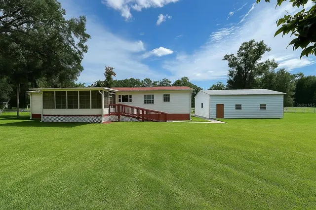 a view of a house with backyard and sitting area