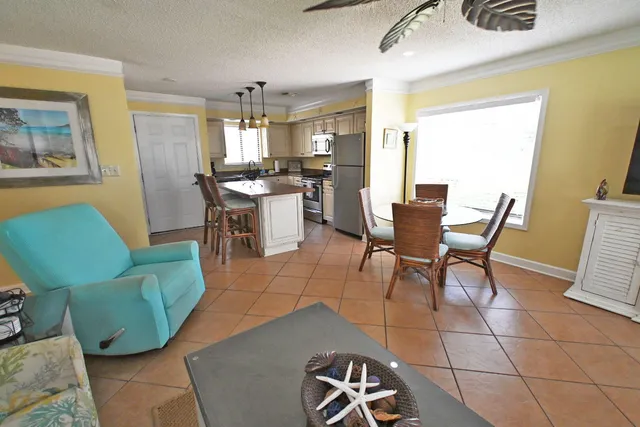 a living room with furniture a dining table and a refrigerator