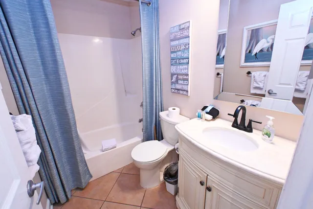 a bathroom with a sink a toilet a mirror and shower