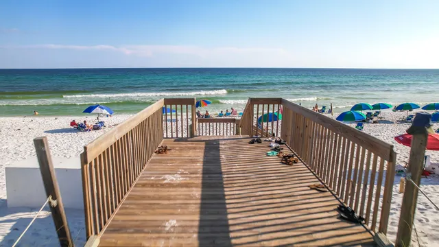 an aerial view of ocean and residential houses with outdoor space