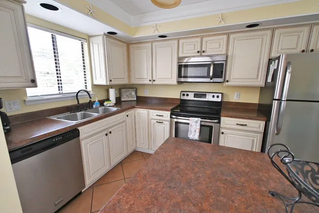 a kitchen with granite countertop a refrigerator stove and sink