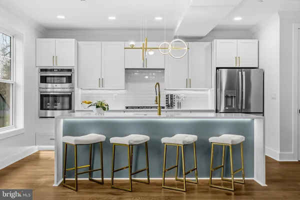 a kitchen with stainless steel appliances granite countertop a table chairs sink and cabinets