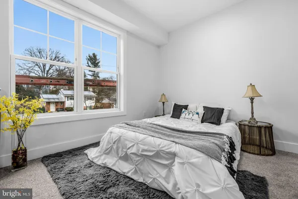 a bedroom with a bed table and a potted plant