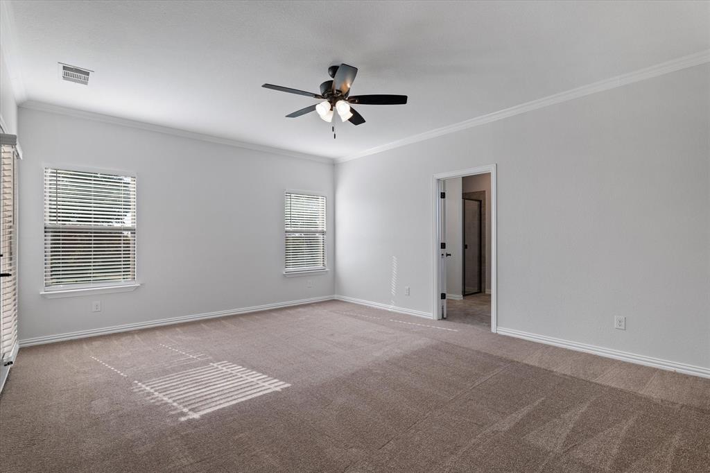 3511 West J E Woody Road Springtown, TX 76082 - Photo 17 of 34 Carpeted spare room with crown molding and a ceiling fan