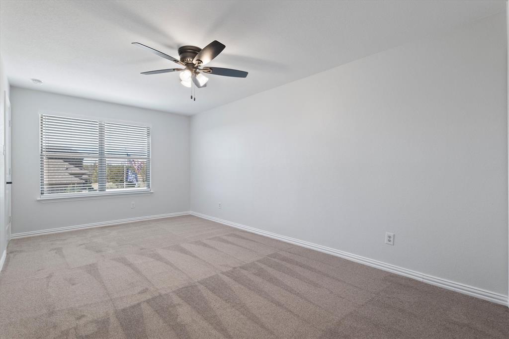 3511 West J E Woody Road Springtown, TX 76082 - Photo 28 of 34 Empty room with light carpet and ceiling fan