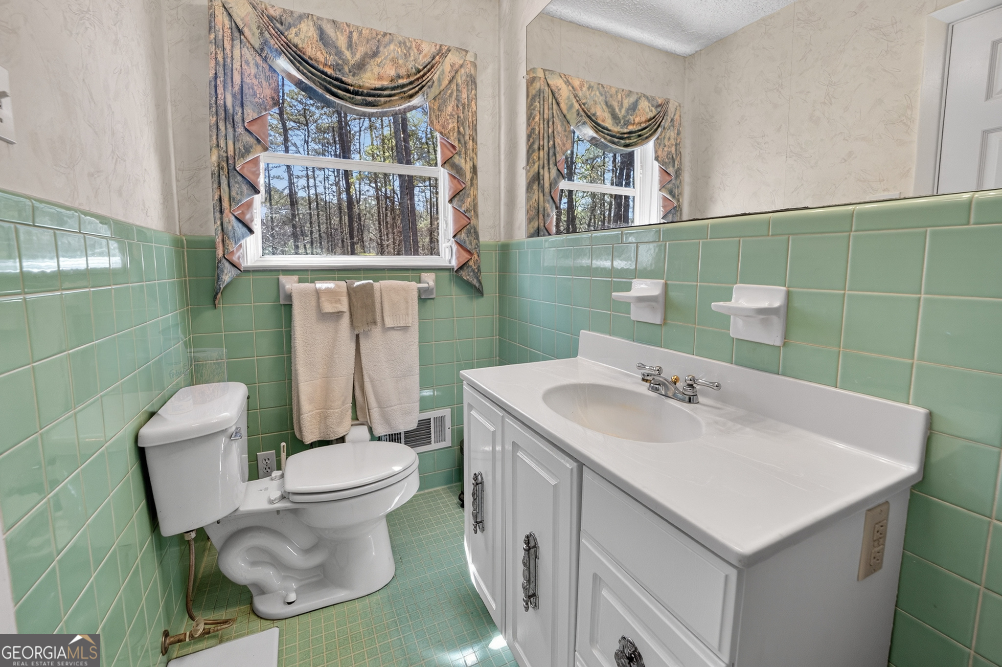 881 Rockbridge Road Southwest Lilburn, GA 30047 - Photo 19 of 44 a bathroom with a sink a toilet and a mirror
