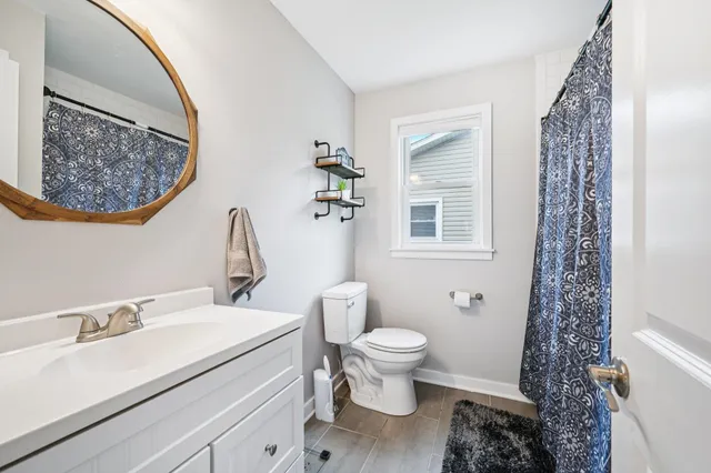 a bathroom with a sink toilet and a mirror