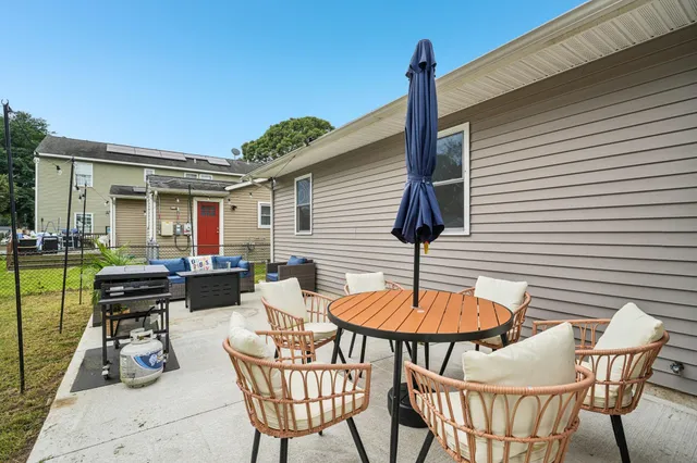 a patio with a table and chairs and a barbeque