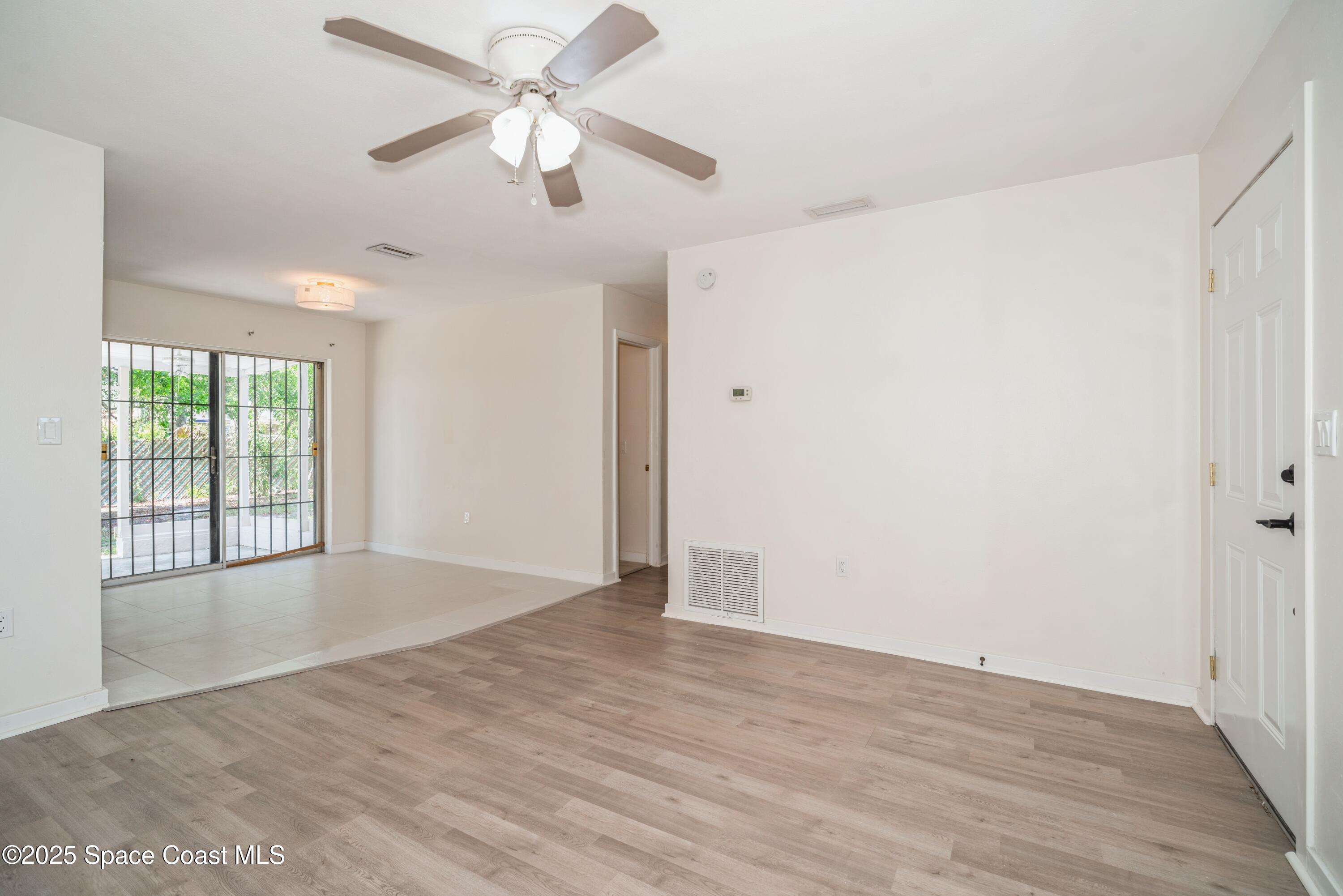 1671 Ollie Street Cocoa, FL 32922 - Photo 4 of 11 an empty room with wooden floor fan and windows