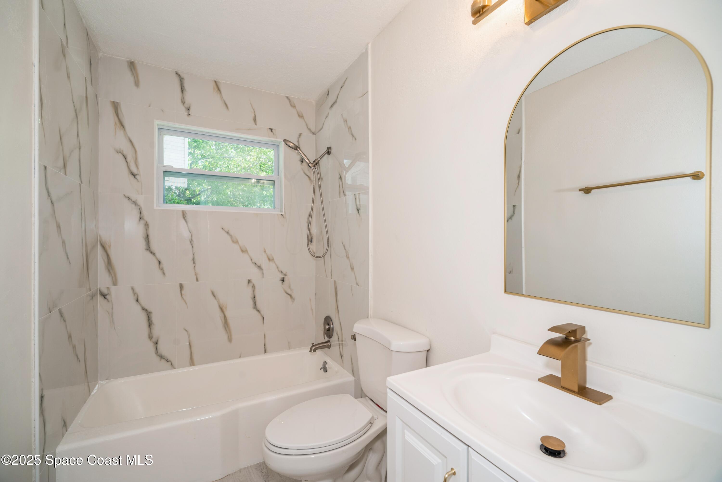 1671 Ollie Street Cocoa, FL 32922 - Photo 9 of 11 a bathroom with a sink a toilet and shower