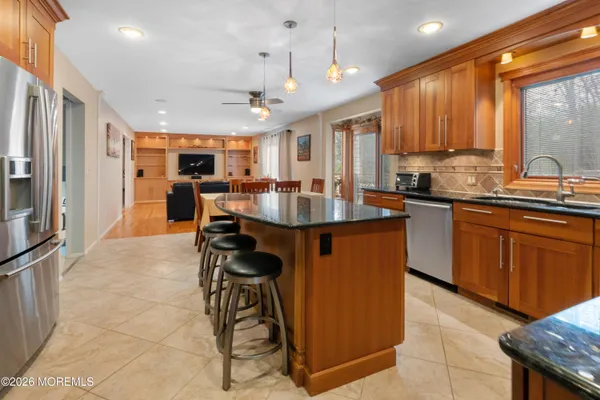 a kitchen with stainless steel appliances granite countertop table chairs sink and cabinets