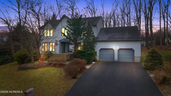 a view of a house with a yard and covered with tree