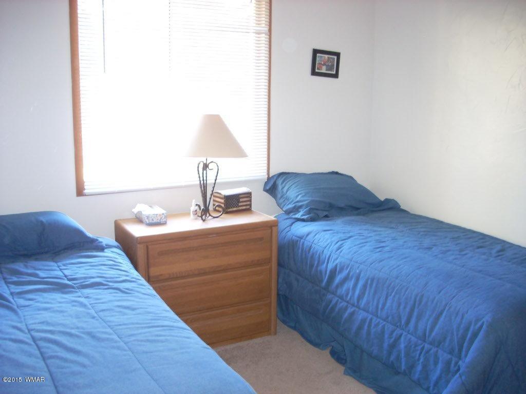 2963 Hunters Road Overgaard, AZ 85933 - Photo 17 of 19 a room with a bed and a lamp