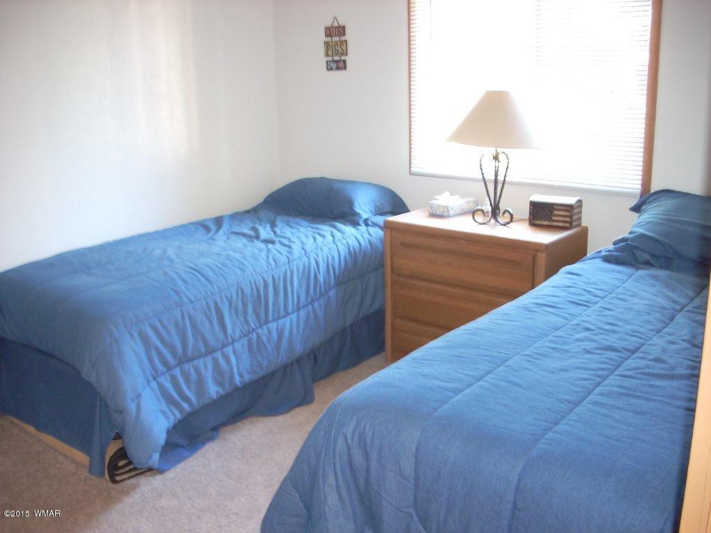 2963 Hunters Road Overgaard, AZ 85933 - Photo 18 of 19 a bedroom with a bed and a lamp