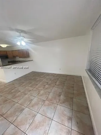 a view of a livingroom with an empty space and a hallway